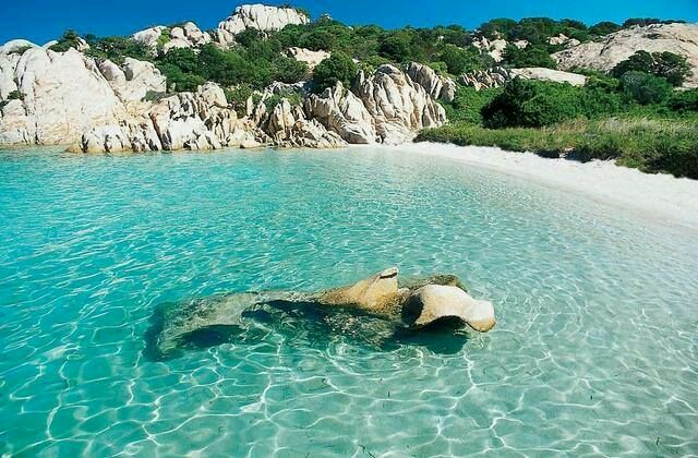 Tour Fabatour su una spiaggia incantevole circondata da colline e rocce in Sardegna