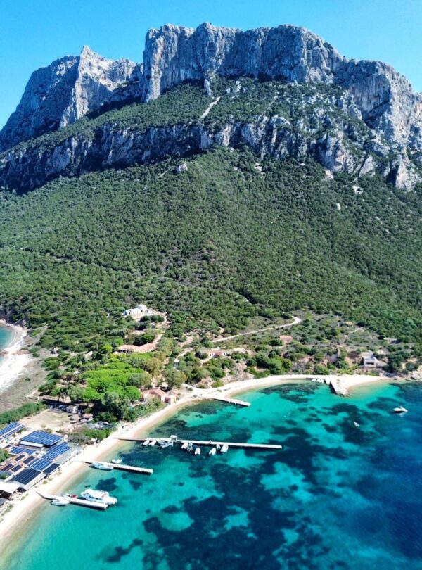 Vista panoramica dell’Isola di Tavolara con spiaggia, pontili e mare cristallino
