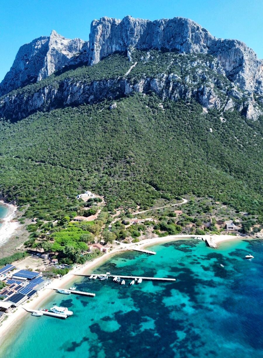Vista panoramica dell’Isola di Tavolara con spiaggia, pontili e mare cristallino
